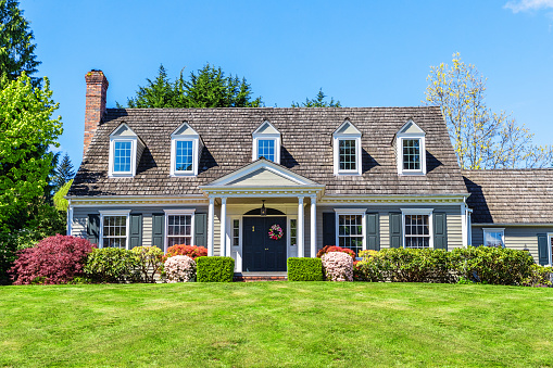 Photo of a suburban American cottage style home on a bright, sunny spring day