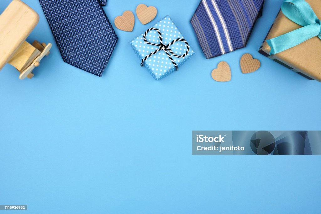 Fathers Day top border of gifts, ties and hearts on a blue background Fathers Day top border of gifts, ties and hearts on a blue background. Top view with copy space, Father's Day Stock Photo