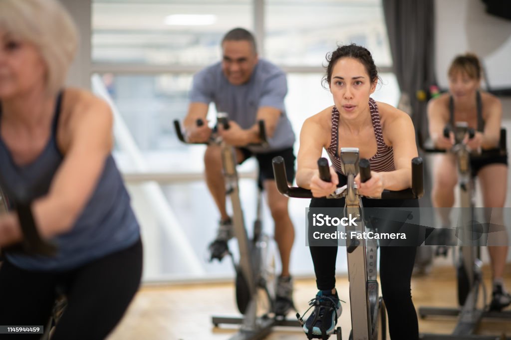 Group exercise class A group of multi-ethnic friends spend time working out one afternoon. They are bonding while taking a exercise class together. Exercising Stock Photo