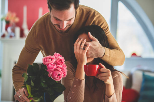 istock Man holding hand over woman's eyes before he gives her present 1145944756