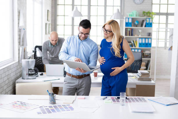 istock Coworker discussing ideas with pregnant colleague at work 1145944804