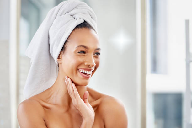 Good skin makes it a good start to the day Shot of an attractive young woman going through her morning beauty routine at home woman wrapped in bath towel stock pictures, royalty-free photos & images