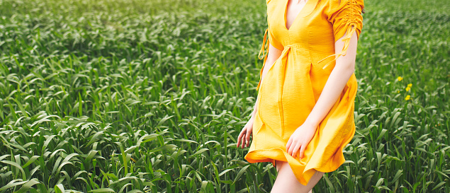 Beautiful girl in the flowers field with yellow dress