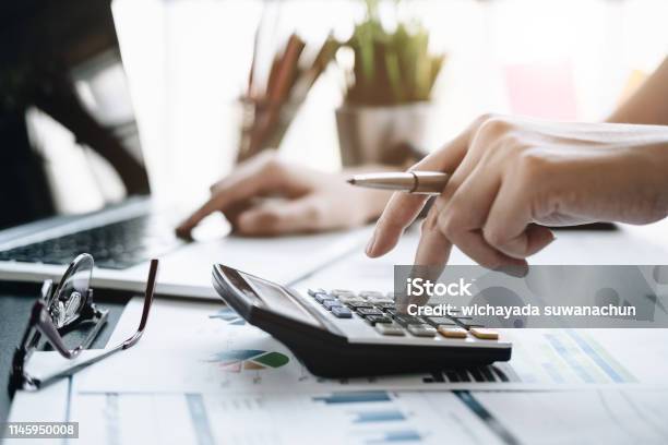 Close Up Business Woman Using Calculator And Laptop For Do Math Finance On Wooden Desk In Office And Business Working Background Tax Accounting Statistics And Analytic Research Concept Stock Photo - Download Image Now