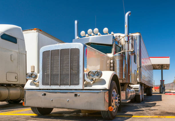 istock White big rig classic powerful semi truck with chrome accessories and refrigerator semi trailer standing on fuel station in Utah for fill the tanks and continue trip 1145954545
