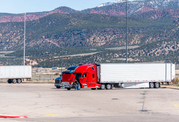 chauffeur de camion réparant cassé rouge gros camion semi-remorque sur l’arrêt de camion au milieu des hautes montagnes dans l’utah - semi truck truck red truck driver photos et images de collection