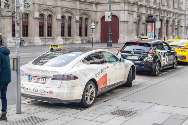 Vienna, Austria - January 15th,2019: Electric vehicles taxi Tesla model s, Nissan Leaf and Hyundai waiting for passengers in Vienna old icty center. State Opera theather on background Vienna, Austria - January 15th,2019: Electric vehicles taxi Tesla model s, Nissan Leaf and Hyundai waiting for passengers in Vienna old icty center. State Opera theather on background. theather stock pictures, royalty-free photos & images