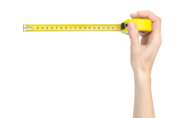 istock Woman's hand holding measuring tape tool. Isolated on white. 1145963486