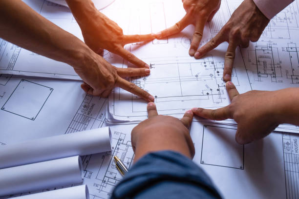 istock Engineering submitting a finger on blueprint to the house to work together, construction concept. Engineer concept 1145964510