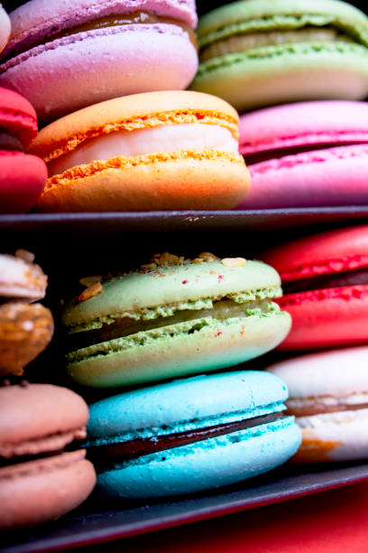istock Tasty different colored macarons in black box on light background 1145966666