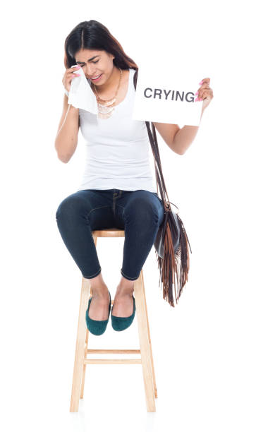 istock Beautiful latino female sitting on a stool and is crying 1145970137