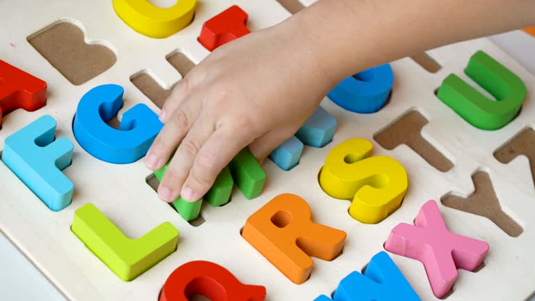 Child hand playing Alphabet puzzle.