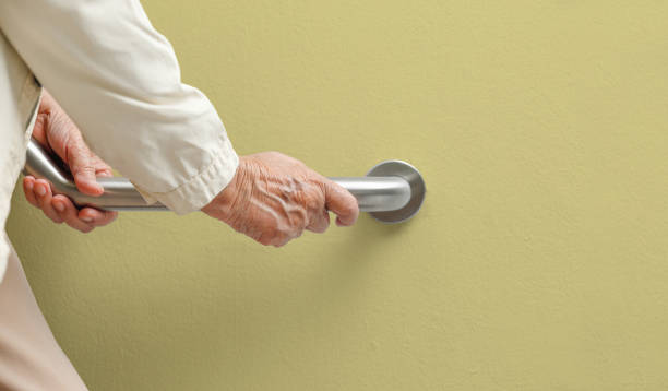 istock Elderly woman holding on handrail for safety walk steps 1145971485
