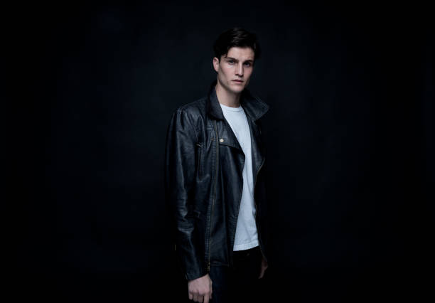 istock Good looking man wearing a leather jacket in front of black background 1145971777
