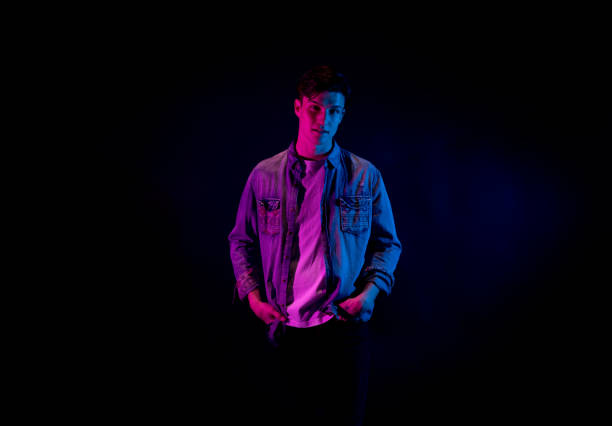 istock Good looking man wearing a button down shirt in front of black background 1145972663