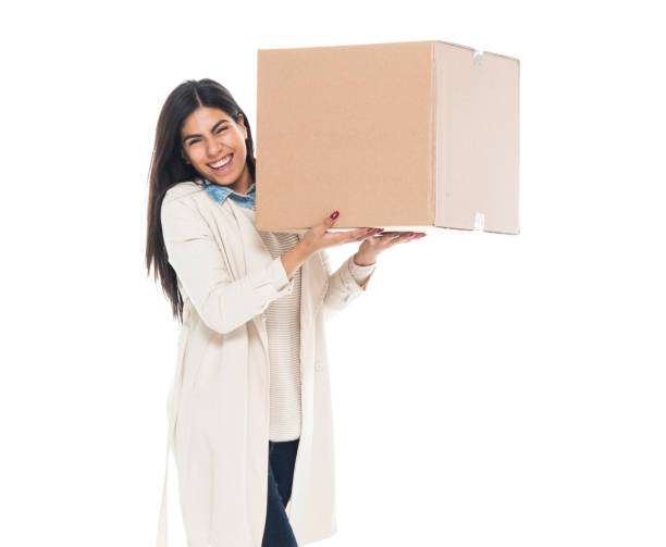 istock Attractive young latino female is holding a box 1145972810