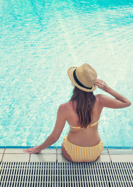 istock Young woman relaxing in swimming pool 1145972838