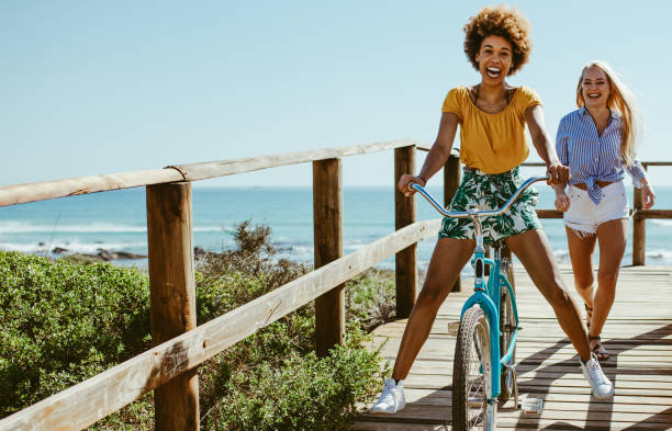 istock Girls having fun with bike on boardwalk 1145975420