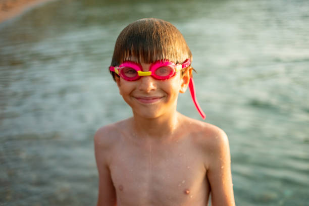 The boy lies in water on his back with closed eyes. Boy relaxing at hotel swimming pool in summer.
