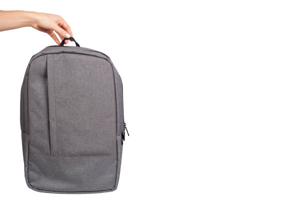 istock Hand with gray textile school bag, city street backpack 1145976482