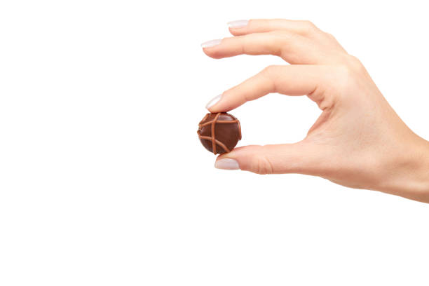 Hand with chocolate candy, sweet dessert closeup stock photo