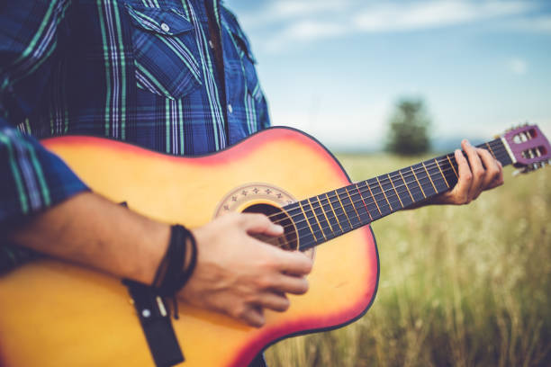 istock Man standing in wheat field and playing guitar 1145978716