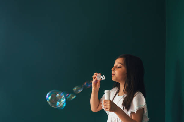 istock Little girl having fun blowing bubbles 1145980317