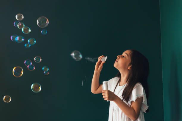 istock Little girl having fun blowing bubbles 1145980327
