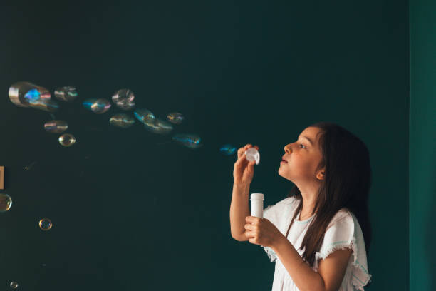 istock Little girl having fun blowing bubbles 1145980330
