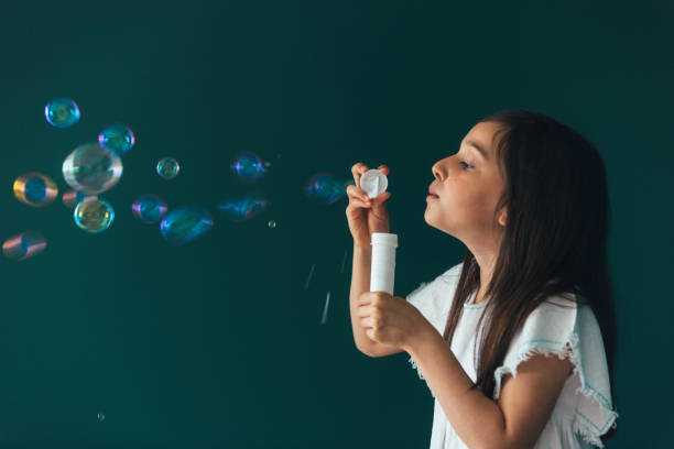 istock Little girl having fun blowing bubbles 1145980337