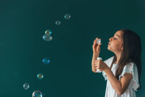 istock Little girl having fun blowing bubbles 1145980339