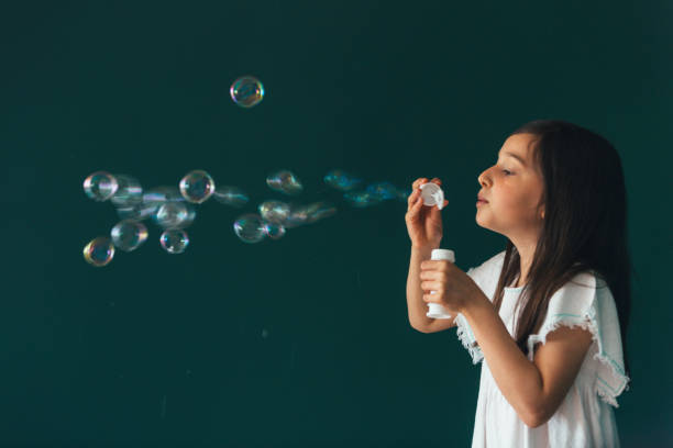 istock Little girl having fun blowing bubbles 1145980353