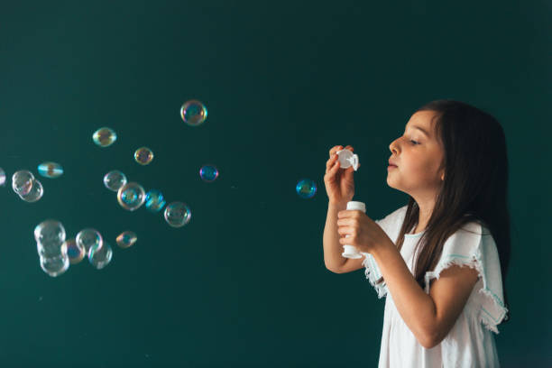 istock Little girl having fun blowing bubbles 1145980356