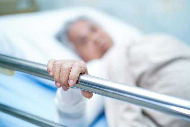 アジアの高齢者または高齢の老婦人患者は、看護病院病棟でベッドに横たわっている間、強い健康で明るい顔を微笑む : 健康な強い医療概念 - old senior adult women tired ストックフォトと画像