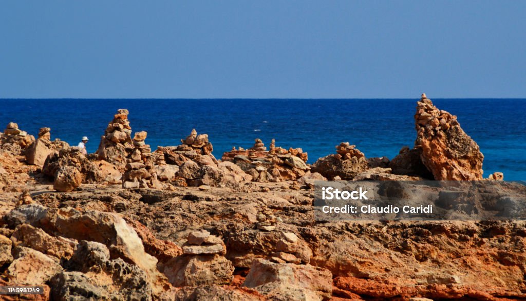 Cairns manmade stone towers at Cap de Ses Salines, Majorca island Majorca island Beach Stock Photo