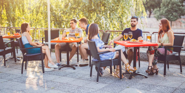 jovens que relaxam na seção do pátio - sidewalk cafe built structure cafe day - fotografias e filmes do acervo