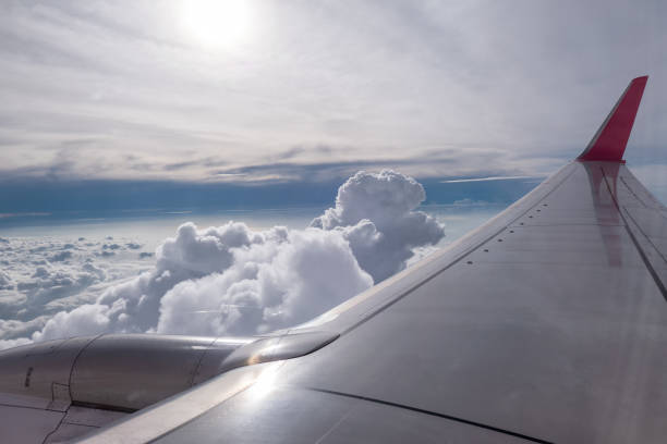 istock Airplane wing flying on clouds in sky 1145984144