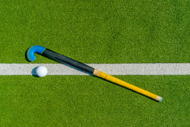 Field hockey stick and ball on green grass Field hockey stick and ball on green grass field hockey stock pictures, royalty-free photos & images