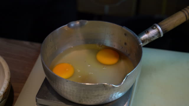 cracking eggs in pot