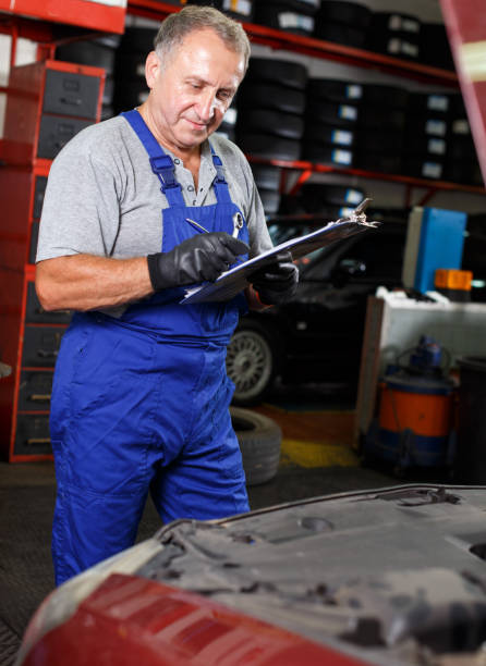 istock Car mechanic writing job sheet 1145988676