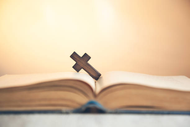 istock wooden cross on the  book 1145992414