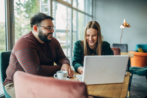 istock Man and woman using laptop in cafe 1145992661