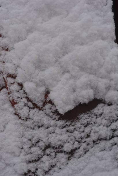 冬の背景、付着した雪、金属製の建設シート上の大雪の美しいカットは、マウンドや谷と古い赤いペンキで塗られました。 - adhering ストックフォトと画像