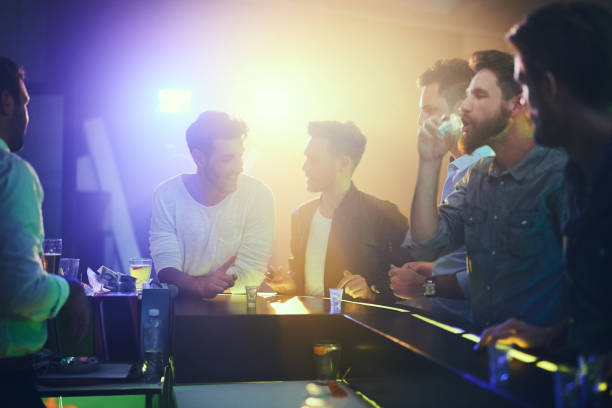 I'll have one more, if you're buying Shot of a group of friends enjoying shots at the bar in a nightclub cocktail bar busy stock pictures, royalty-free photos & images