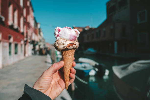 istock Cropped Hand Holding Ice Cream Cone In City 1146000896