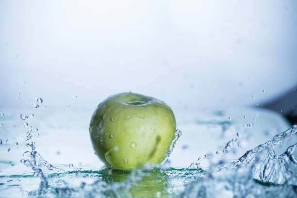 Green apple with freezed water splash and drops without photoshop editing.
