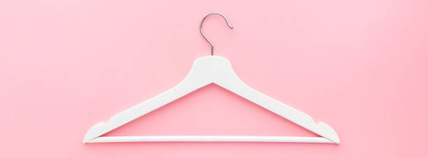 istock White hangers on pastel pink background 1146002485
