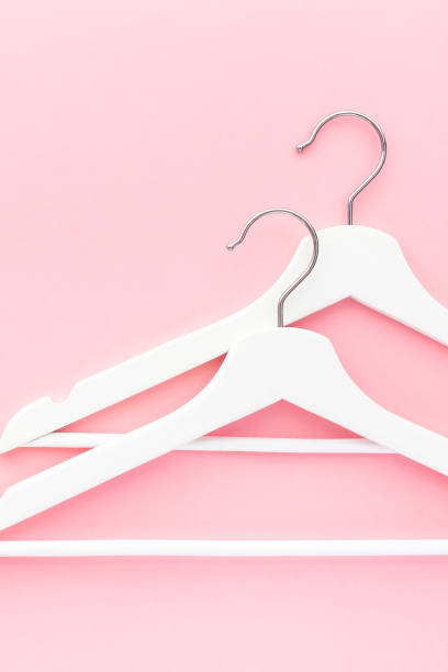 istock White hangers on pastel pink background 1146003293