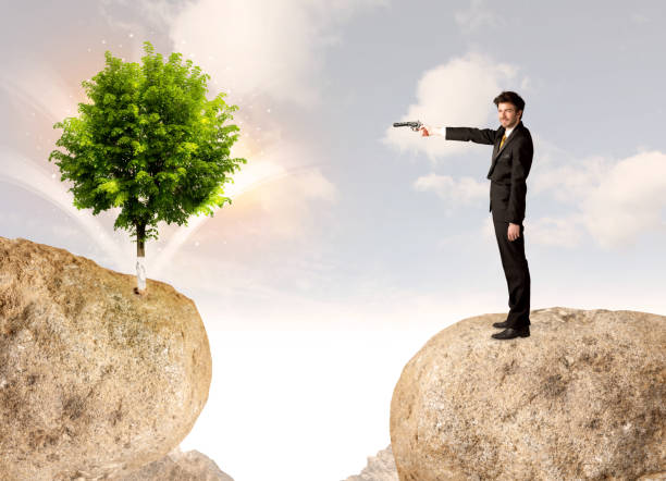 istock Businessman on rock mountain with a tree 1146003907