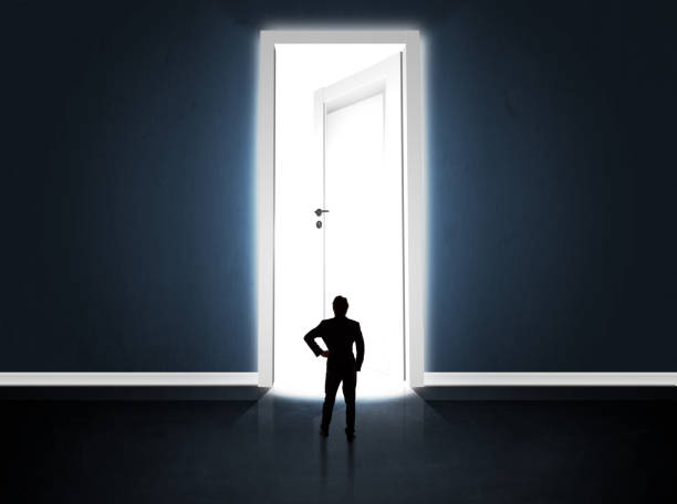istock Business man looking at big bright opened door 1146005350